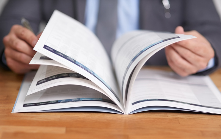 picture of hands flipping pages of a published journal