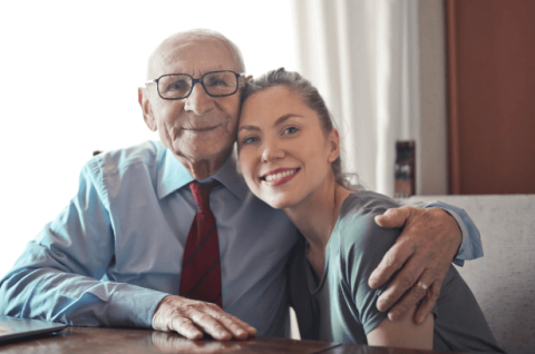 older man with glasses and younger woman smiling